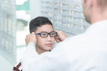 optometrist Glasses wearing glasses to a boy at a lens optical shop