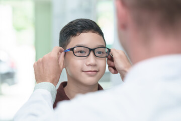 optometrist Glasses wearing glasses to a boy at a lens optical shop