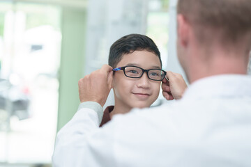 optometrist Glasses wearing glasses to a boy at a lens optical shop