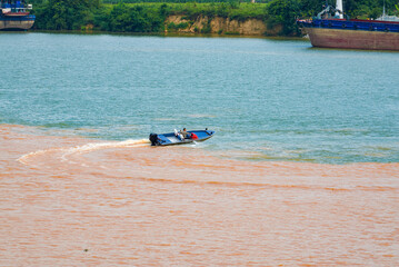 Fototapeta na wymiar A sailor drives a speedboat at the confluence of two rivers