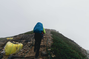 雨の中の山道を進む登山者