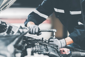 Mechanic works on the engine of the car in the garage. Repair se