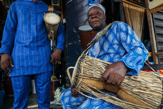 African father playing the talking drum for son