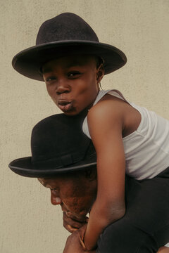 Child wearing a hat having a good time while on fathers shoulders