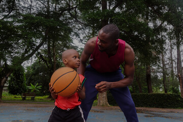 Father coaching son on basketball tips