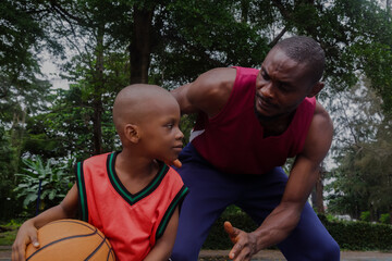 Father and little son at basketball training