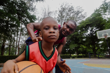 Obraz premium Parent and son playing basketball