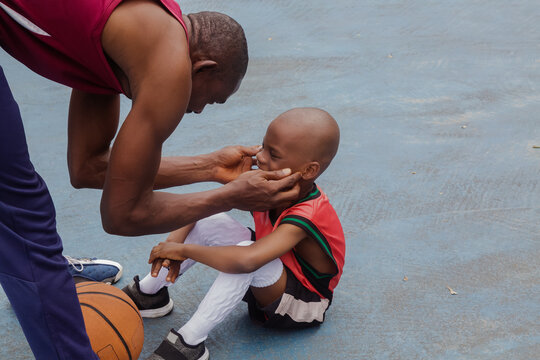 Father encouraging child on the basketball court
