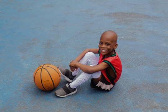 Child sitting at the basketball court