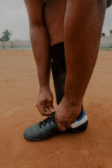 Man ties shoelace to soccer boots