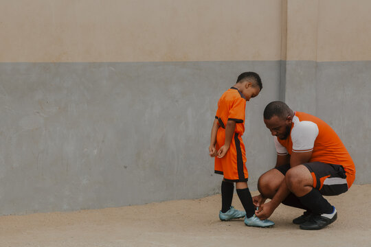 Father adjusting laces for son 