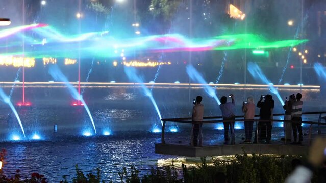 Autumn, 2022 - Tashkent, Uzbekistan - Musical fountain in Tashkent City. People watch the performance of the musical fountain in the evening. Large fountain with evening illumination.