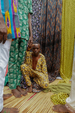 African brothers holding hands standing while last brother in genuflection