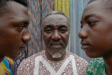 African dad in late 50s standing between two sons 