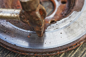 Hammer chops rust from an old rusty brake disc