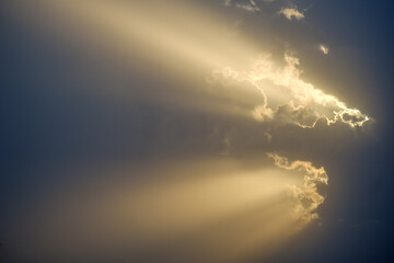 Fototapeta na wymiar Sun rays emerging from behind a cloud