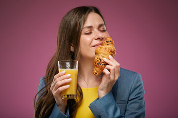 Happy woman eating croissant with juice. Modern fast food concept. Isolated advertising portrait on pink back.