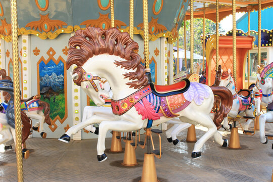 carousel in an amusement holiday park. Merry-go-round with horses on a fairground