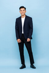 Young handsome southeast Asian man wearing semi-formal suit smiling and looking at camera in blue...