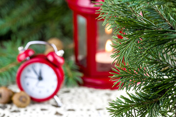 Blurred Christmas (New Year) background with clock. Focus on fir-tree branches
