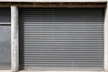 metallic gray curtain of a store closed for bankruptcy roller garage gate access