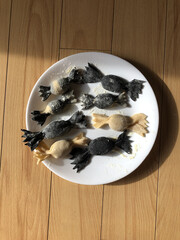 Squid ink gyozas in the shape of caramelle pasta 
