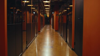 Fired upset man walking down in office hallway, holding box with books and personal stuff, saying goodbye to colleagues, looking at camera. Male employee leaving marketing company