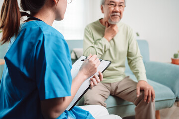 Obraz premium Asian caregiver talking senior male patient checkup in living room at home. Older elderly man consults after physical therapy. Nurse assistance rescue concept.