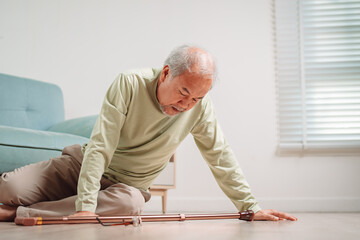Asian senior man falling on the ground with walker in living room at home. Elderly older mature male having an accident heart attack for emergency help support from hospital. Insurance health care.