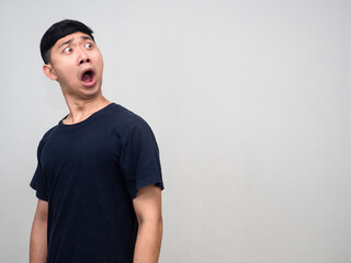 Asian man black shirt shocoked face turn around to looking at copy space