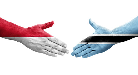 Handshake between Botswana and Monaco flags painted on hands, isolated transparent image.