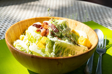Vegetable salad with bacon in wooden bowl with sunshine in the morning time