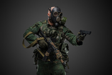 Portrait of military russian man with rifle dressed in modern camouflage uniform and gas mask.