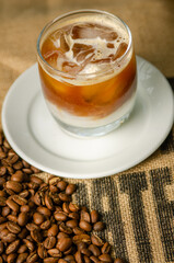iced coffee on a table with roasted coffee beans