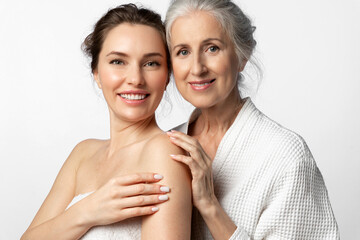 Two tender beautiful women of different ages and generations together on a white background. The...