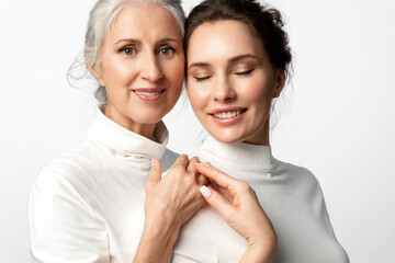 Beautiful women of different ages and generations together on a white background. Daughter and her...