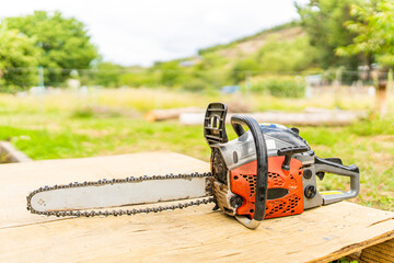 Chainsaw on a wooden table in a garden