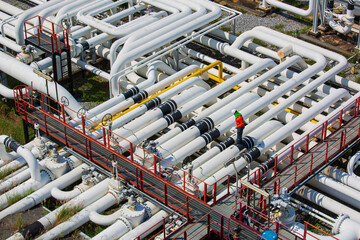 Top view male worker inspection at steel long pipes and pipe elbow valve in station oil factory during refinery valve of visual check record pipeline oil