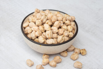 Chickpeas (garbanzo bean) in a ceramic bowl, isolated on white background, close up view