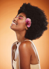 Beauty, skincare and makeup with a model black woman in studio on an orange background with an afro and smile. Face, hair and happy with an attractive young female posing for cosmetics or wellness