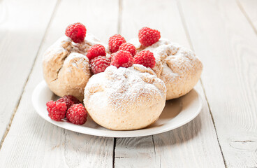 Buns sprinkled with powdered sugar and raspberries high key photo