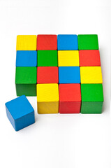 colorful wooden cubes forming a square shape, one moved away