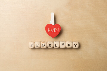Hello February minimal background made with one wooden heart and some die