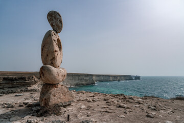 Fototapeta na wymiar Sculpture symbol made of large pebbles against the blue sky