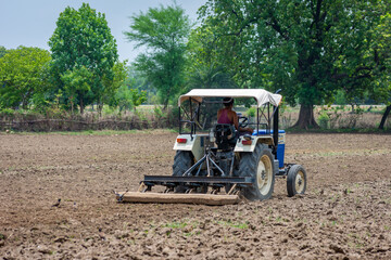 Farmer in tractor preparing land for sowing