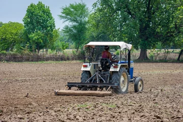 Foto op Canvas Farmer in tractor preparing land for sowing © SSG PHOTO