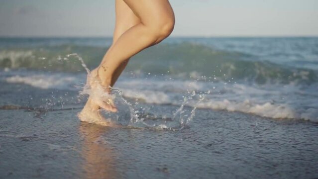 Feet of a person running along the seashore