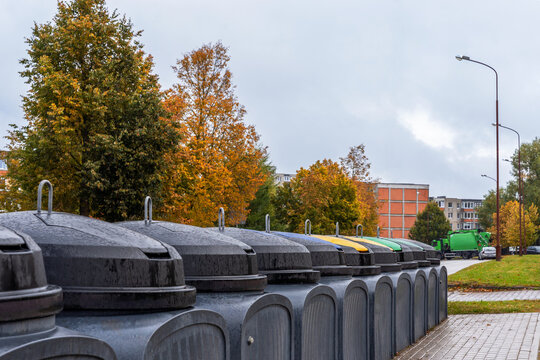 Urban waste management, city street view in autumn. Garbage collection semi underground containers  installed in city yard area. Sustainable environment concept.