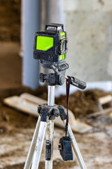 Laser level on a tripod at a construction site. Close-up. Taking measurements with a laser.