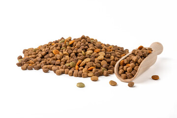 A pile of dry cat and dog food and a scoop for food on a white background.